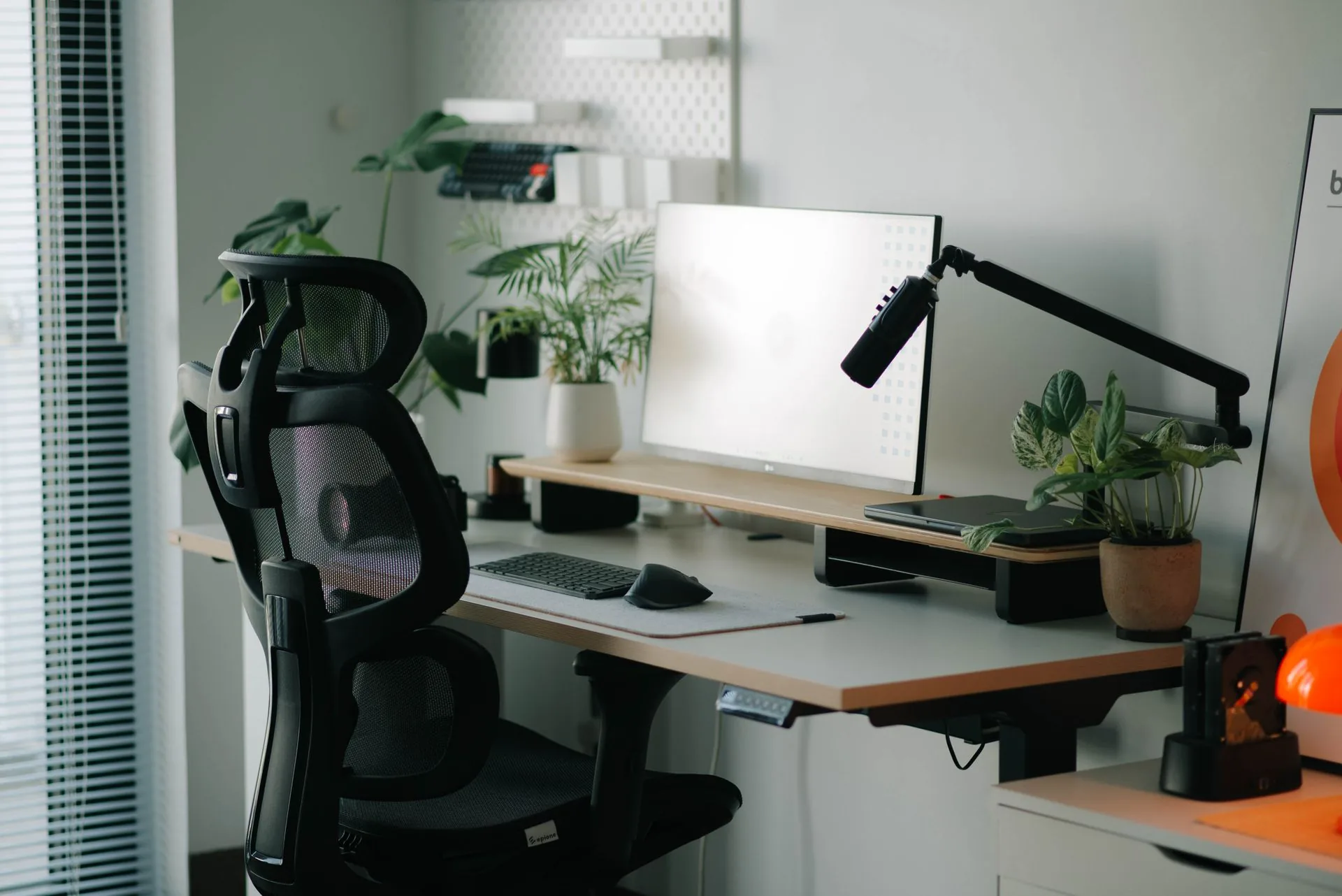 Posto de trabalho com cadeira ajustável, monitor, teclado e mouse.
